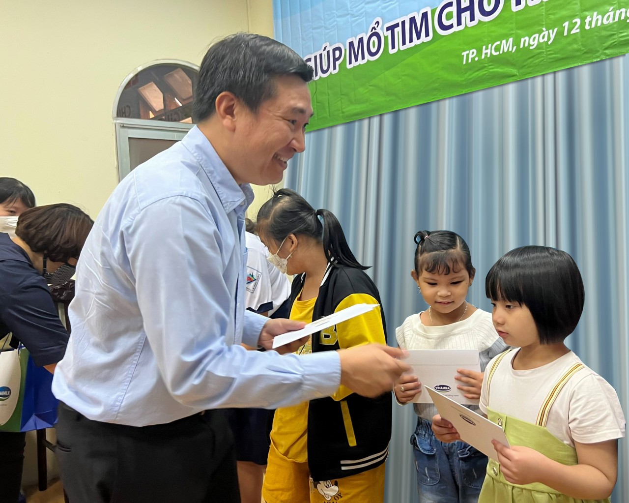 Bé Kỳ Duyên (áo thun trắng, váy xanh) nhận quà động viên từ đại diện công ty Vinamilk. Bé Kỳ Duyên (áo thun trắng, váy xanh) nhận quà động viên từ đại diện công ty Vinamilk.