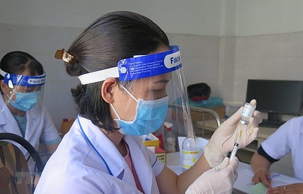 A health worker prepares to administer Covid-19 vaccine. Photo: VNA A health worker prepares to administer Covid-19 vaccine. Photo: VNA