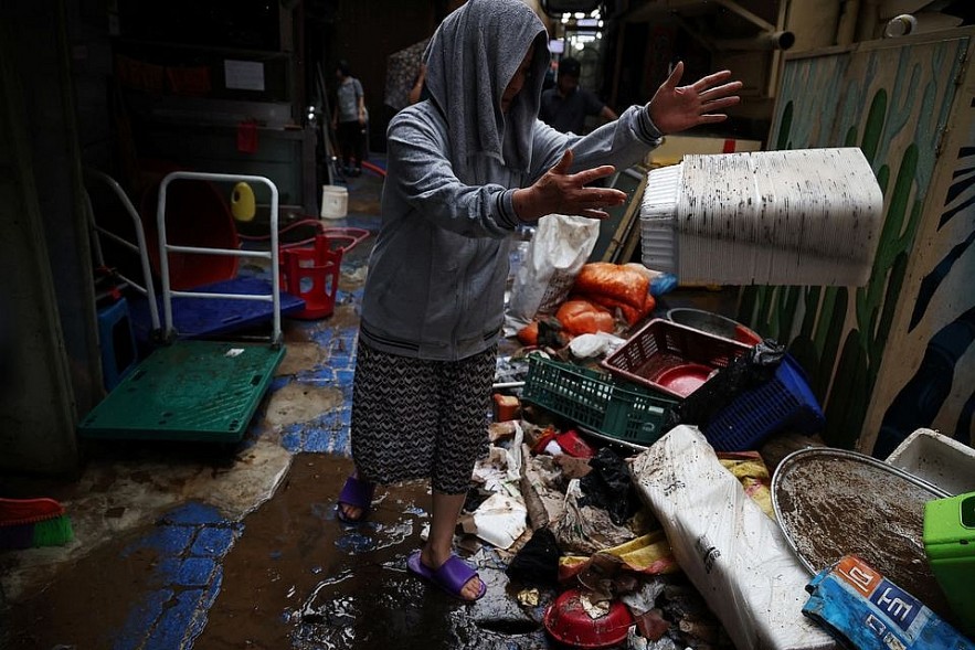 Kim Sun-ok cleans up debris from her restaurant damaged by flood after torrential rain at a traditional market in Seoul, South Korea, August 9, 2022. REUTERS/Kim Hong-Ji Kim Sun-ok cleans up debris from her restaurant damaged by flood after torrential rain at a traditional market in Seoul, South Korea, August 9, 2022. REUTERS/Kim Hong-Ji