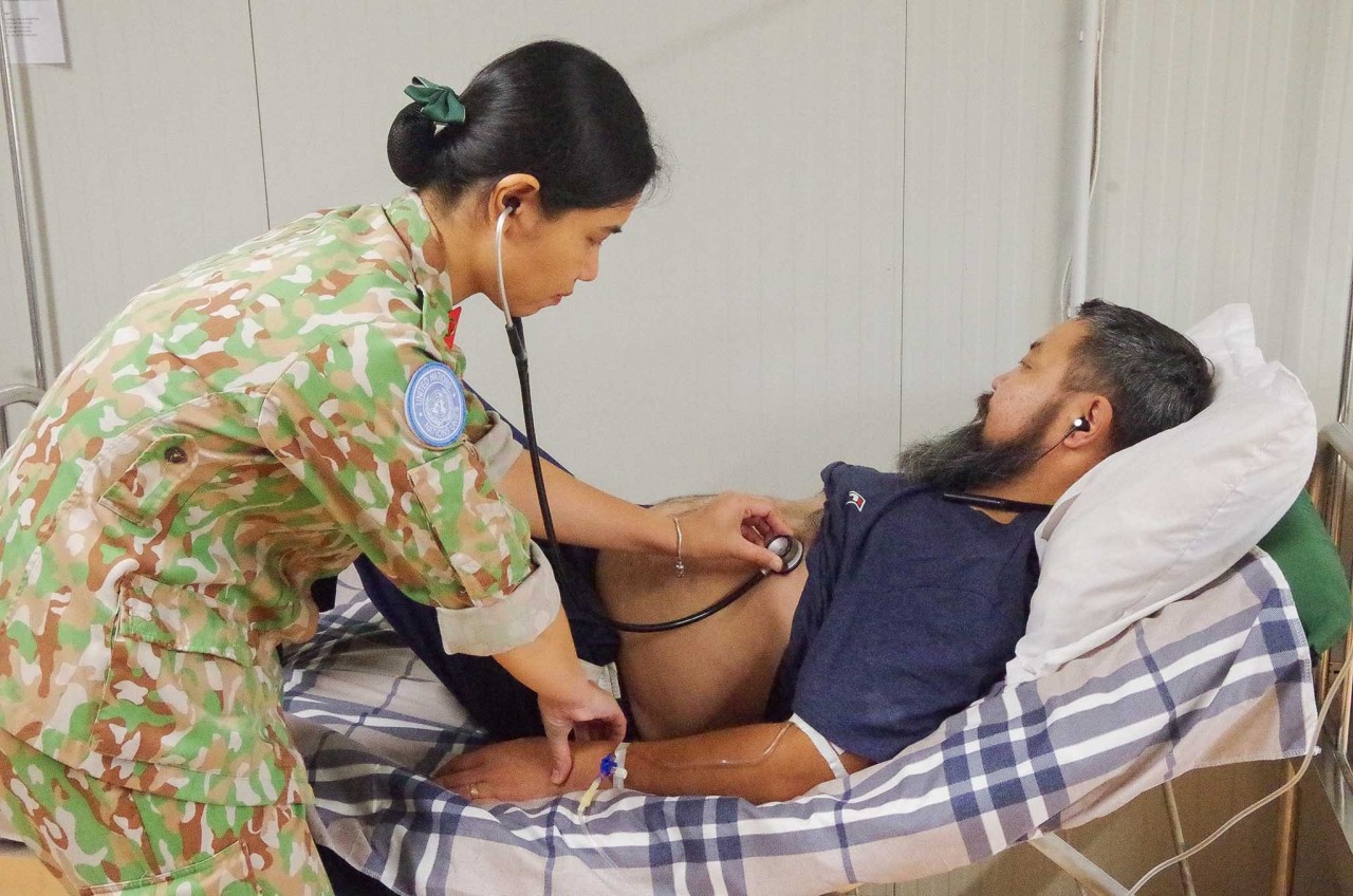 Vietnamese blue-beret doctor examines Mongolian patient who suffered acute pancreatitis. Photo: BVDC 2.4 Vietnamese blue-beret doctor examines Mongolian patient who suffered acute pancreatitis. Photo: BVDC 2.4