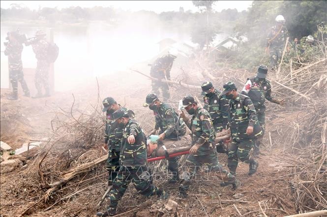 Các chiến sĩ đang đưa một người dân bị bùn, đất bị vùi lấp đi cấp cứu trong một tình huống giả định tại diễn tập (Ảnh: Phạm Kiên/Phóng viên TTXVN tại Lào) Các chiến sĩ đang đưa một người dân bị bùn, đất bị vùi lấp đi cấp cứu trong một tình huống giả định tại diễn tập (Ảnh: Phạm Kiên/Phóng viên TTXVN tại Lào)