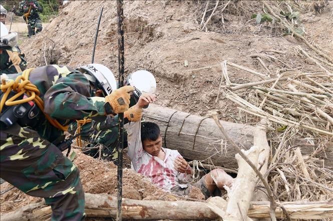 Các chiến sĩ đang đưa một người dân bị cây đè và bị vùi lấp đi cấp cứu trong một tình huống giả định tại diễn tập. (Ảnh: Phạm Kiên/Phóng viên TTXVN tại Lào). Các chiến sĩ đang đưa một người dân bị cây đè và bị vùi lấp đi cấp cứu trong một tình huống giả định tại diễn tập. (Ảnh: Phạm Kiên/Phóng viên TTXVN tại Lào).