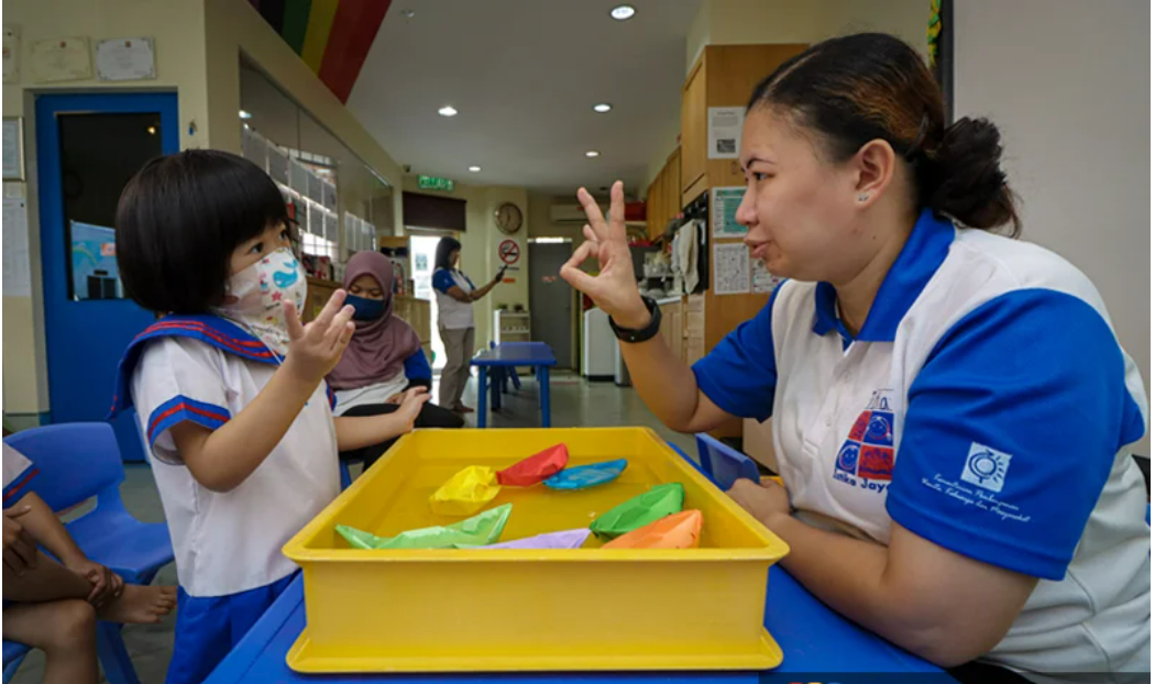 Giáo viên đang dạy trẻ em cách sử dụng ngôn ngữ ký hiệu Giáo viên đang dạy trẻ em cách sử dụng ngôn ngữ ký hiệu