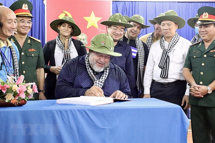 Thủ tướng Manuel Marrero Cruz viết sổ lưu niệm sau khi tham quan địa đạo (Ảnh: Hồng Giang/TTXVN).