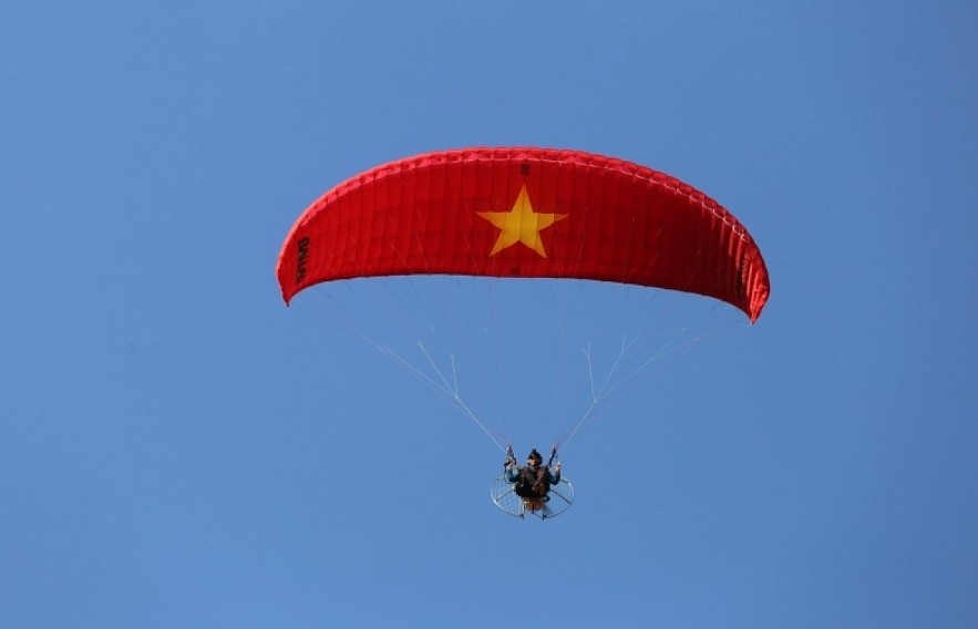 Paragliding over golden rice terrace fields in Northern Vietnam Paragliding over golden rice terrace fields in Northern Vietnam
