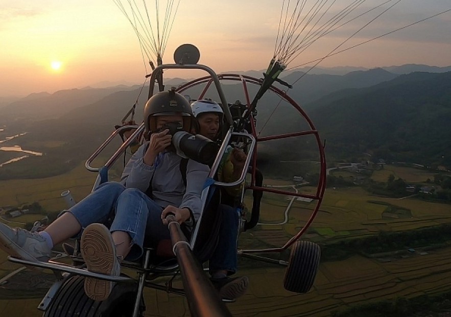 Paragliding over golden rice terrace fields in Northern Vietnam Paragliding over golden rice terrace fields in Northern Vietnam