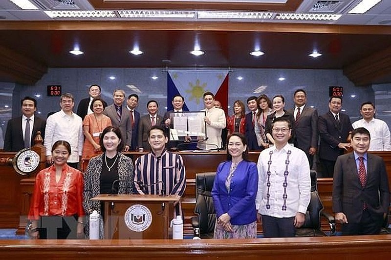President of the Philippine Senate Juan Miguel Zubiri hands over the resolution to NA Chairman Hue. (Photo: VNA) President of the Philippine Senate Juan Miguel Zubiri hands over the resolution to NA Chairman Hue. (Photo: VNA)