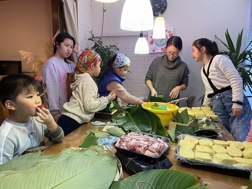 Children learn to make 'banh chung' (square glutinous rice cake), a traditional dish of Vietnamese people during the Tet (Lunar New Year) festival. Photo: VNA Children learn to make 'banh chung' (square glutinous rice cake), a traditional dish of Vietnamese people during the Tet (Lunar New Year) festival. Photo: VNA