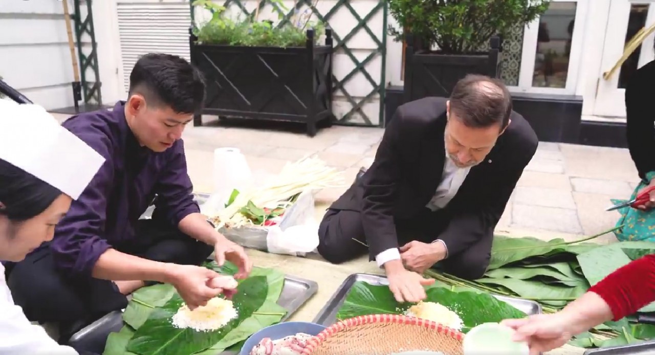 Đại sứ Australia tại Việt Nam Andrew Goledzinowski tự tay gói bánh chưng (Ảnh cắt từ clip). Đại sứ Australia tại Việt Nam Andrew Goledzinowski tự tay gói bánh chưng (Ảnh cắt từ clip).