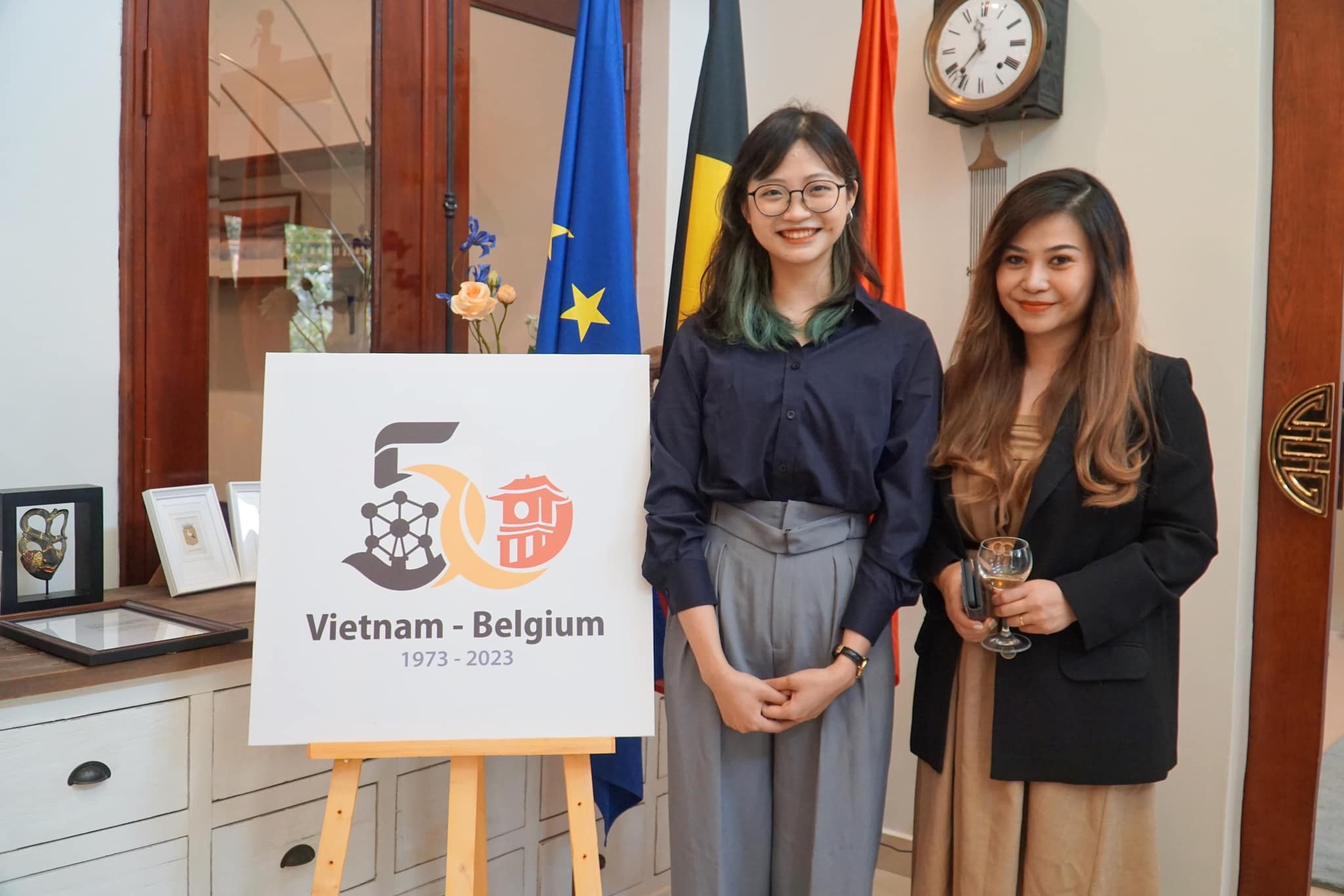 Tác giả Lý Khánh Linh (thứ hai, từ phải sang) bên logo chính thức kỷ niệm 50 năm quan hệ ngoại giao Việt Nam-Bỉ (Ảnh: ĐSQ Bỉ tại Việt Nam). Tác giả Lý Khánh Linh (thứ hai, từ phải sang) bên logo chính thức kỷ niệm 50 năm quan hệ ngoại giao Việt Nam-Bỉ (Ảnh: ĐSQ Bỉ tại Việt Nam).