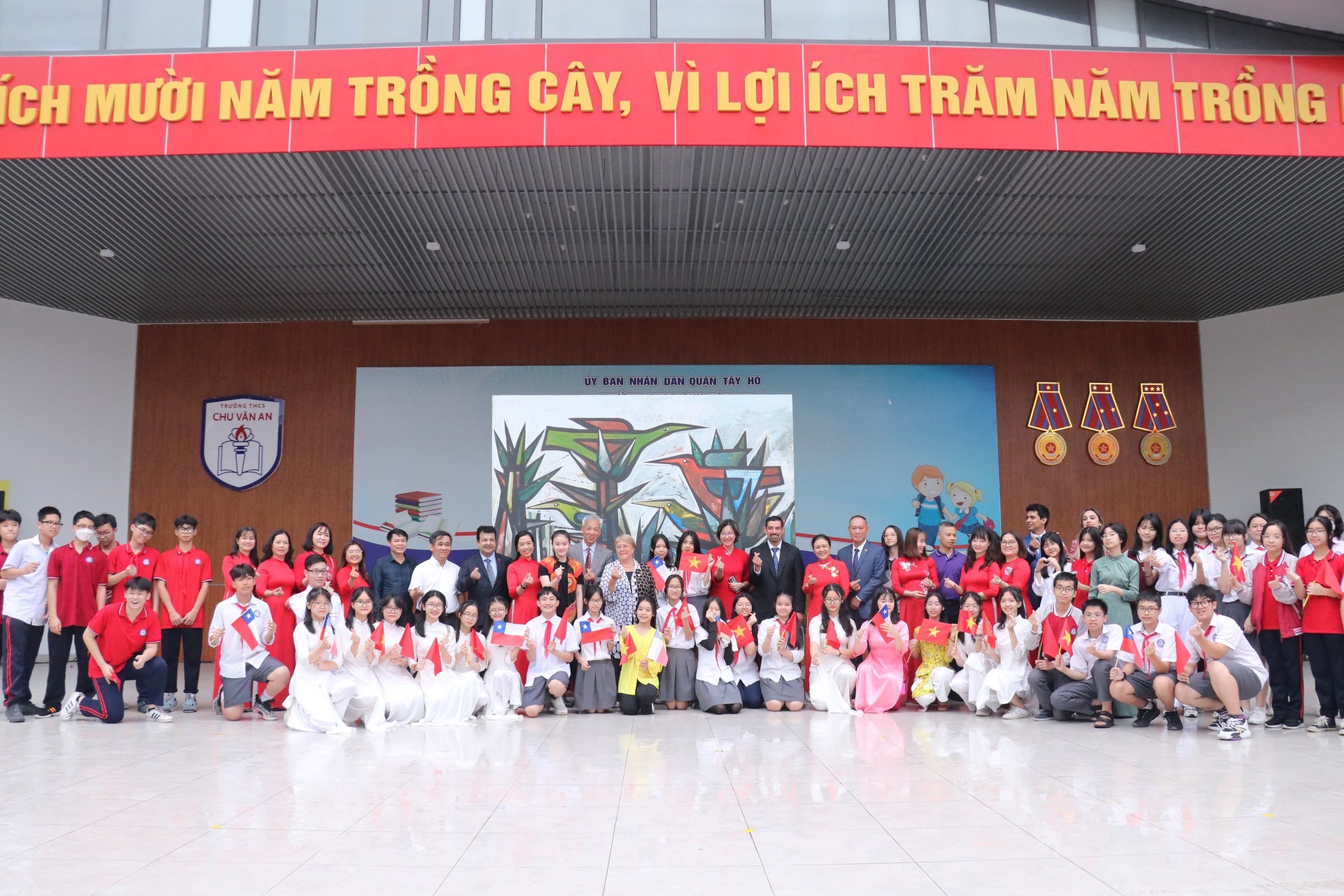 Các em học sinh trường THCS Chu Văn An (Hà Nội) chụp ảnh cùng các vị khách mời bên bức tranh sơn dầu của họa sĩ Alejandro Mono Gonzalez (Ảnh: Thu Hà). Các em học sinh trường THCS Chu Văn An (Hà Nội) chụp ảnh cùng các vị khách mời bên bức tranh sơn dầu của họa sĩ Alejandro Mono Gonzalez (Ảnh: Thu Hà).