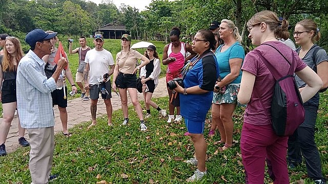 A Vietnamese tour guide speaking to foreign tourists at Mỹ Sơn Sanctuary in the central province of Quang Nam. Photo: VNS A Vietnamese tour guide speaking to foreign tourists at Mỹ Sơn Sanctuary in the central province of Quang Nam. Photo: VNS