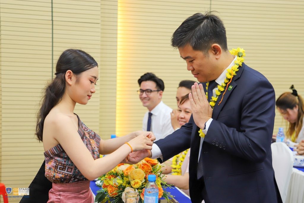 Sinh viên Lào thực hiện nghi thức Buộc chỉ cổ tay.