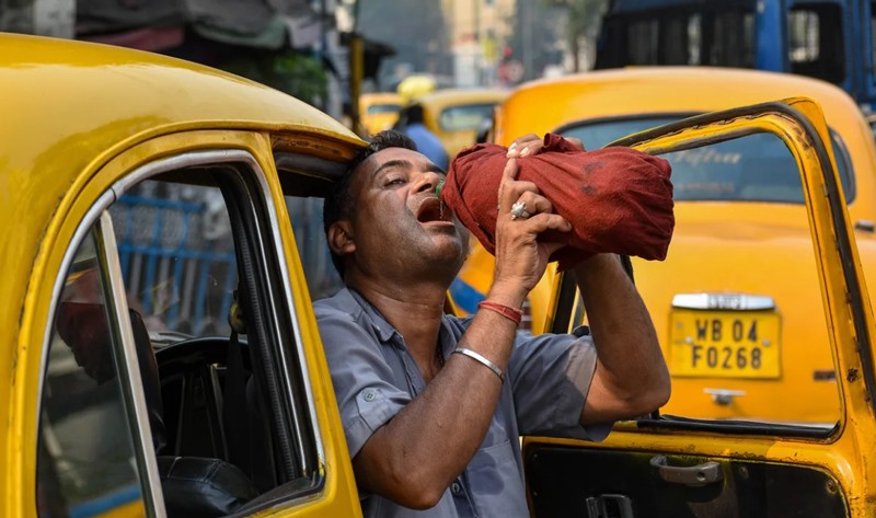 Một tài xế taxi uống nước từ chai trong cái nóng buổi trưa ở Kolkata, Ấn Độ, vào ngày 18/4 (Ảnh: Getty). Một tài xế taxi uống nước từ chai trong cái nóng buổi trưa ở Kolkata, Ấn Độ, vào ngày 18/4 (Ảnh: Getty).