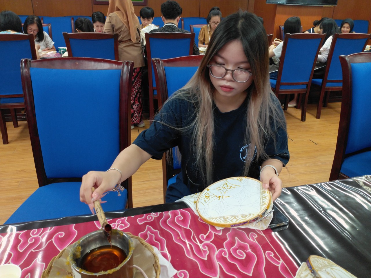 Bạn Minh Tâm, sinh viên năm 4 trường Đại học Kinh tế Quốc dân chia sẻ: “Trước khi đến buổi trải nghiệm mình đã xem video làm Batik của nghệ nhân Indonesia. Mình thấy người ta làm rất nhanh, đều và đẹp nên mình rất hào hứng muốn tham gia buổi trải nghiệm này. Khi được trải nghiệm, mình thấy khó nhất ở công đoạn điều khiển lượng nến ra khỏi bút mà không làm nến rớt trên vải. Thông qua buổi trải nghiệm thì mình đã biết thêm được một điều mới của văn hóa truyền thống Indonesia” (Ảnh: Mai Anh).