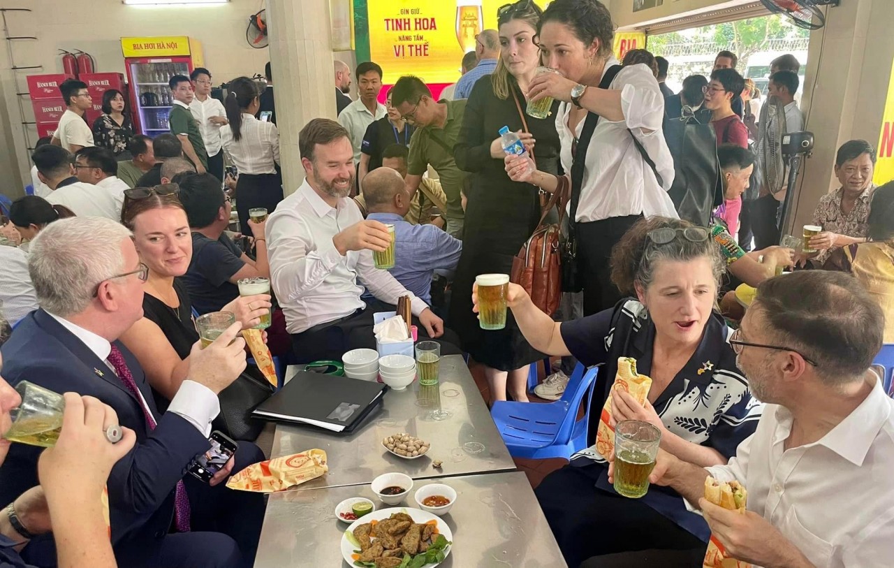 Australian officials sip locally brewed beer and eat banh mi. Photo: Thanh Nien newspaper Australian officials sip locally brewed beer and eat banh mi. Photo: Thanh Nien newspaper