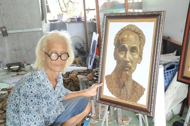Le Van Nghia and his portrait of Uncle Ho made from lotus leaves.  Photo: T.LUY