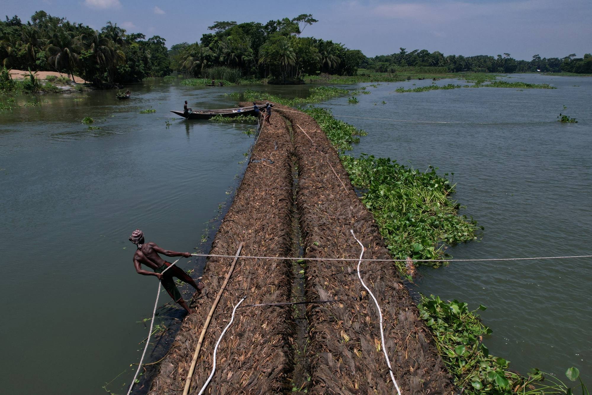Nông dân ở Pirojpur Bangladesh di chuyển bè nổi trên sông Belua (Ảnh Reuters). Nông dân ở Pirojpur Bangladesh di chuyển bè nổi trên sông Belua (Ảnh Reuters).