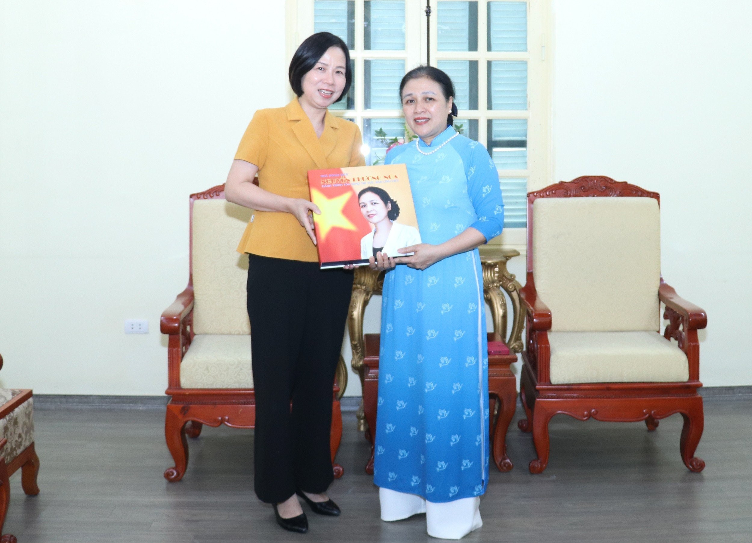 Tổng Giám đốc Thông tấn xã Việt Nam Vũ Việt Trang (bìa trái) tặng Vũ Việt Trang đã tặng Đại sứ Nguyễn Phương Nga cuốn sách ảnh Tri ân đóng góp của Đại sứ Nguyễn Phương Nga cho sự bình đẳng và phát triển của phụ nữ Việt Nam