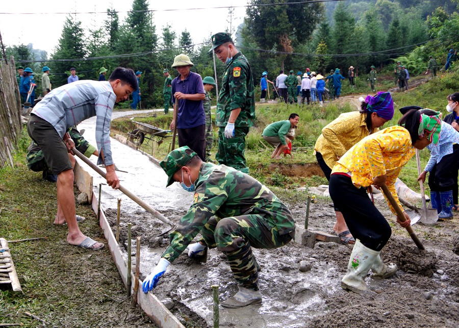 Cán bộ, chiến sỹ Đồn Biên phòng Bản Máy giúp nhân dân làm đường bê tông. (Ảnh: Báo Hà Giang) Cán bộ, chiến sỹ Đồn Biên phòng Bản Máy giúp nhân dân làm đường bê tông. (Ảnh: Báo Hà Giang)