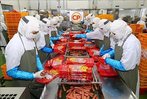 Workers produce sausage at the factory of the Thailand-invested CP Vietnam Livestock JSC in Hanoi. (Photo: VNA) Workers produce sausage at the factory of the Thailand-invested CP Vietnam Livestock JSC in Hanoi. (Photo: VNA)