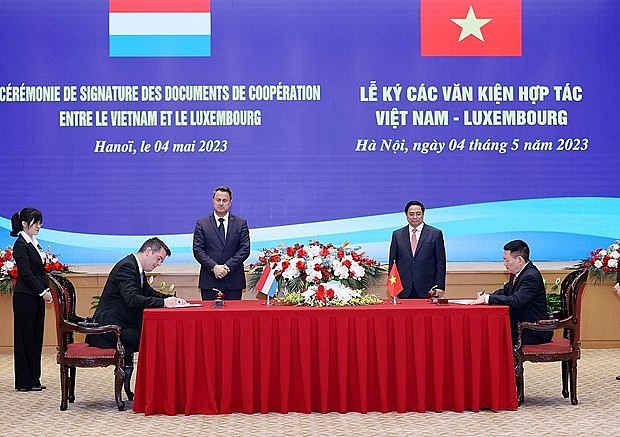 Vietnamese PM Pham Minh Chinh (second from right) and his Luxembourg counterpart Xavier Bettel (centre) witness the signing of the agreement on the strategic partnership in green finance in Hanoi on May 4, 2023. (Photo: VNA) Vietnamese PM Pham Minh Chinh (second from right) and his Luxembourg counterpart Xavier Bettel (centre) witness the signing of the agreement on the strategic partnership in green finance in Hanoi on May 4, 2023. (Photo: VNA)
