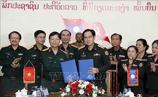 Representatives of Military Hospital 103 of the Vietnam People's Army and Central Hospital 103 of the Lao People's Army exchange the minutes of their discussion at the event (Photo: VNA) Representatives of Military Hospital 103 of the Vietnam People's Army and Central Hospital 103 of the Lao People's Army exchange the minutes of their discussion at the event (Photo: VNA)