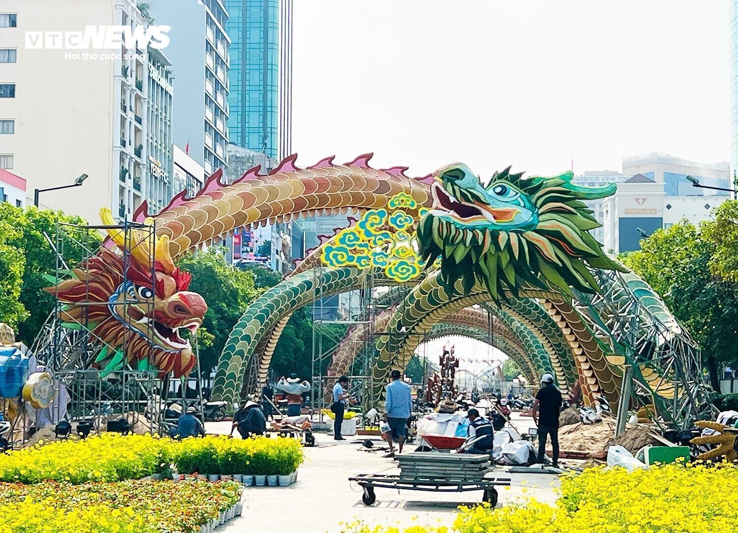 Ngay cổng vào của đường hoa Nguyễn Huệ (TP.HCM) là hai linh vật rồng lớn với tên gọi "Lưỡng Long triều liên" (đôi rồng chầu sen). Mỗi linh vật rồng dài khoảng 120m, lập kỷ lục về kích thước các linh vật xuất hiện trên đường hoa 21 năm qua. Thân rồng nhiều màu sắc rực rỡ, đan chéo vào nhau cao hơn 10m, tạo mái trần. Hai đầu rồng mang dáng vẻ uy nghi, kích thước vòng đầu khoảng 2m, cao hơn 3m so với mặt đất. Miệng rồng ngậm ngọc đường kính 50cm, bên trong chứa đèn thắp sáng. Bên trong cổ có lắp giàn âm thanh, bánh răng cửa để phát ra tiếng động và lắc lư chào du khách. Toàn thân rồng làm bằng kim loại phủ đèn Led. (Ảnh: Hoàng Thọ)