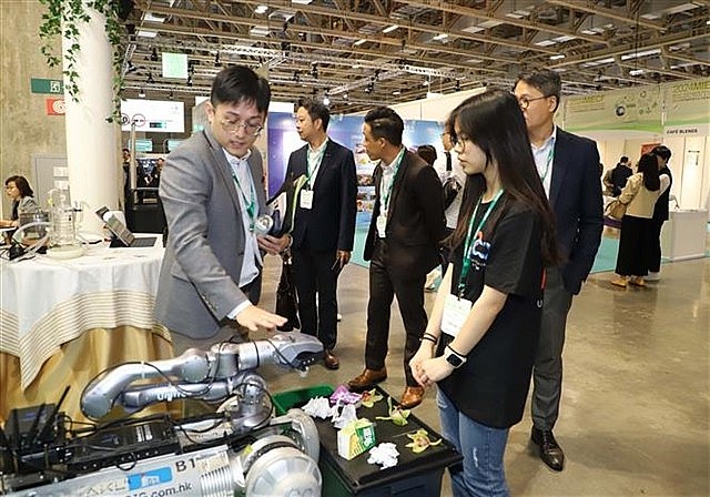 Visitors hear an introduction of a robot to collect and classify rubbish. Visitors hear an introduction of a robot to collect and classify rubbish.