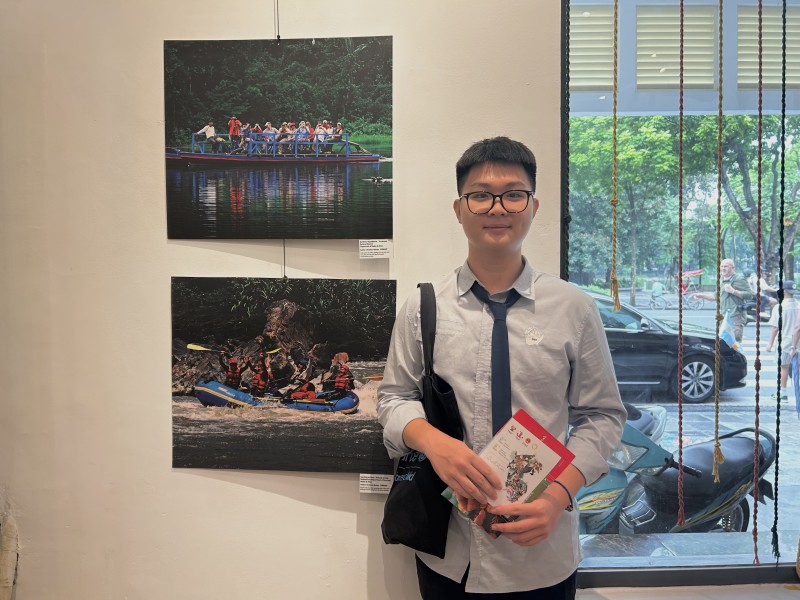 Nguyễn Đức Huy bên cạnh bức ảnh “Kayaking on rivers” mà em ấn tượng tại triển lãm. (Ảnh: Thu Phượng) Nguyễn Đức Huy bên cạnh bức ảnh “Kayaking on rivers” mà em ấn tượng tại triển lãm. (Ảnh: Thu Phượng)