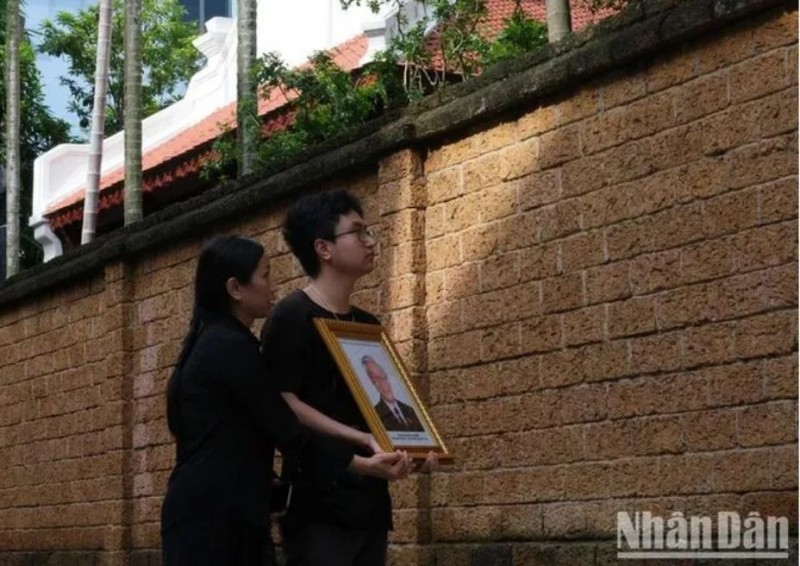 Hai mẹ con chị Lan cầm di ảnh hướng về ngôi nhà của Tổng Bí thư tại làng Lại Đà. Hai mẹ con chị Lan cầm di ảnh hướng về ngôi nhà của Tổng Bí thư tại làng Lại Đà.