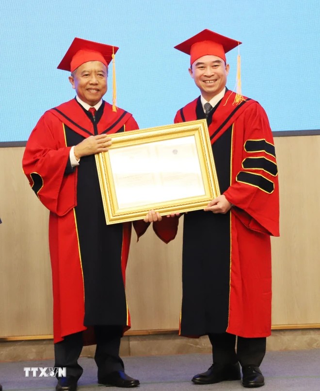 Đại diện Học viện Khoa học và Công nghệ thuộc (Viện Hàn lâm Khoa học và Công nghệ Việt Nam) trao tặng danh hiệu “Giáo sư danh dự” cho Bộ trưởng Bộ Công nghệ và Truyền thông Lào Boviengkham Vongdara. (Ảnh: Xuân Tú/TTXVN) Đại diện Học viện Khoa học và Công nghệ thuộc (Viện Hàn lâm Khoa học và Công nghệ Việt Nam) trao tặng danh hiệu “Giáo sư danh dự” cho Bộ trưởng Bộ Công nghệ và Truyền thông Lào Boviengkham Vongdara. (Ảnh: Xuân Tú/TTXVN)