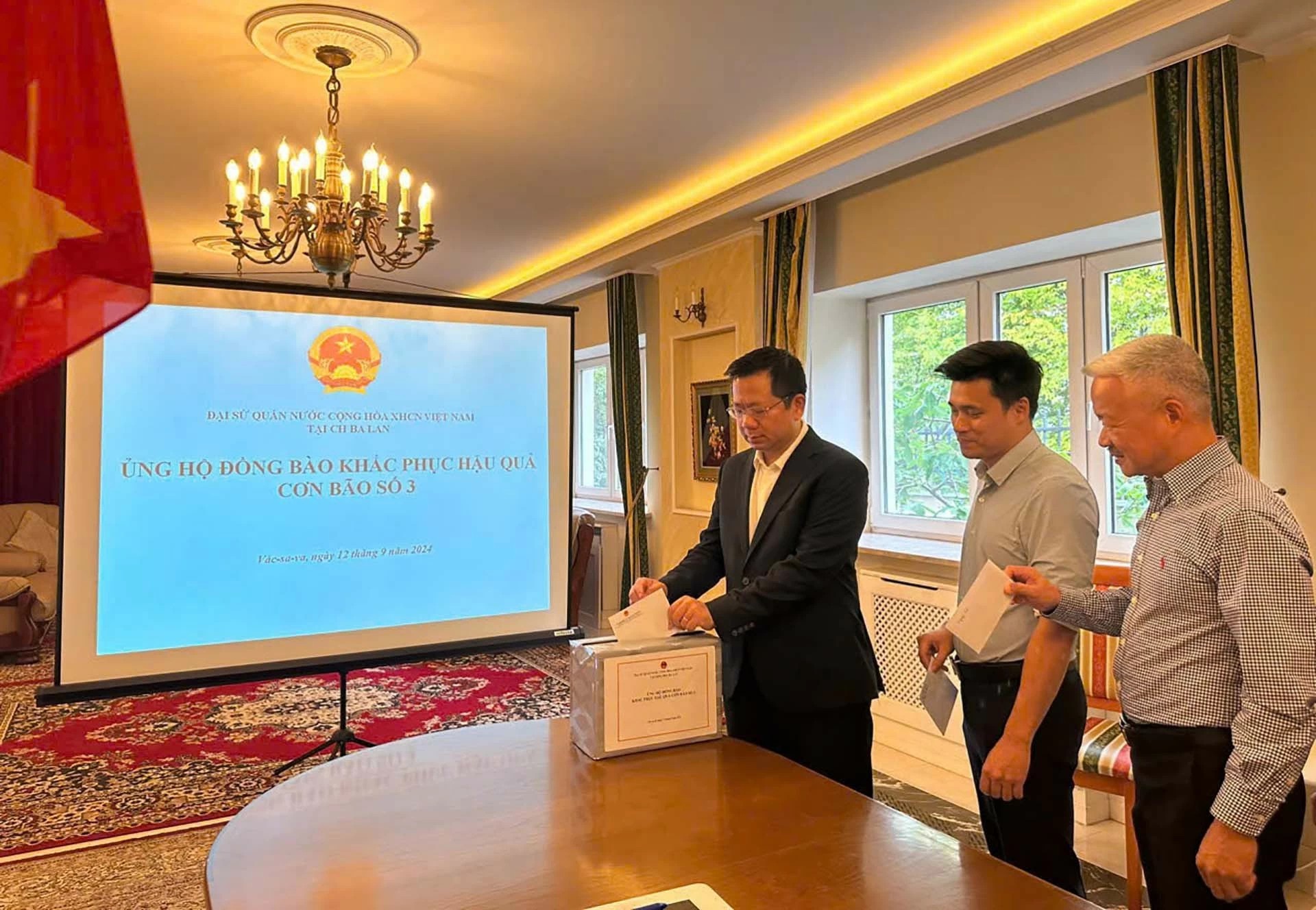 Cán bộ, nhân viên Đại sứ quán Việt Nam tại Ba Lan quyên góp ủng hộ đồng bào khắc phục hậu quả con bão số 3. (Ảnh: SCOV) Cán bộ, nhân viên Đại sứ quán Việt Nam tại Ba Lan quyên góp ủng hộ đồng bào khắc phục hậu quả con bão số 3. (Ảnh: SCOV)