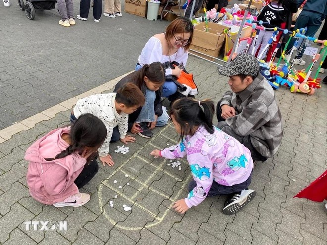 Thiếu nhi chơi trò ô ăn quan tại Tết Trung thu 2024 ở Trung tâm thương mại Đồng Xuân (Berlin, Đức). (Ảnh: TTXVN) Thiếu nhi chơi trò ô ăn quan tại Tết Trung thu 2024 ở Trung tâm thương mại Đồng Xuân (Berlin, Đức). (Ảnh: TTXVN)