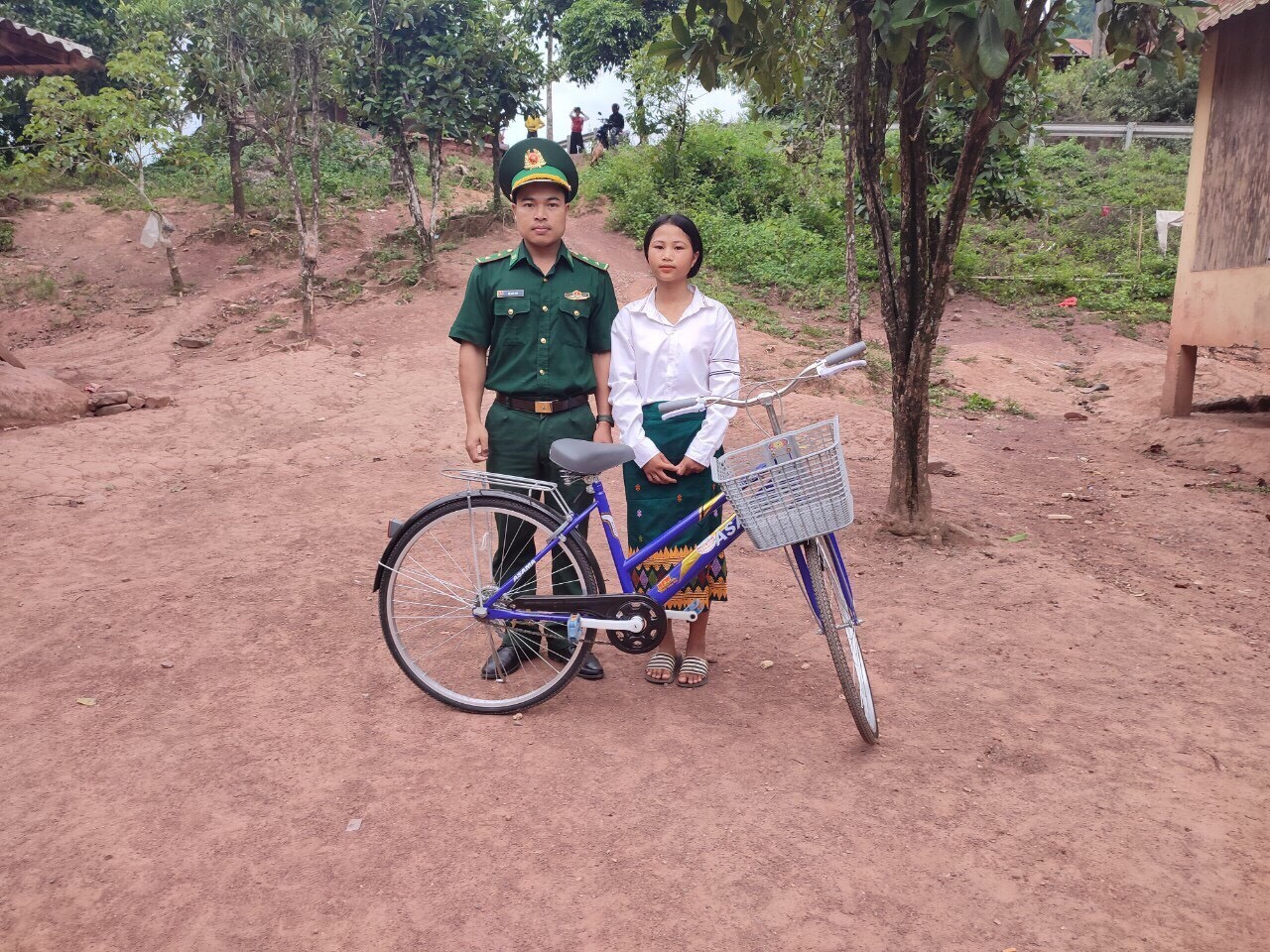 Trung úy Hồ Văn Thủ, Đồn Biên phòng La Lay trao xe đạp cho con nuôi Hồ Thị Nghin. (Ảnh: Thời Đại) Trung úy Hồ Văn Thủ, Đồn Biên phòng La Lay trao xe đạp cho con nuôi Hồ Thị Nghin. (Ảnh: Thời Đại)