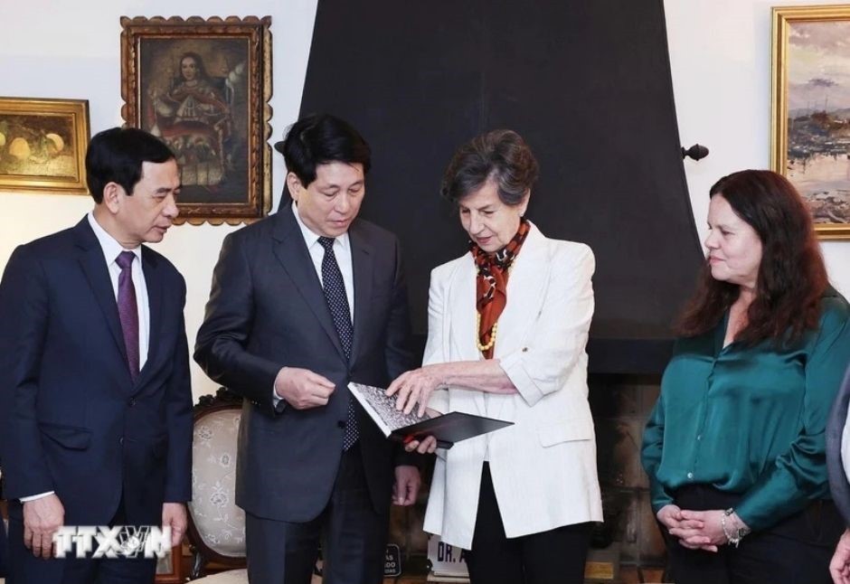 President Luong Cuong and Senator Isabel Allende look at some photos of Chilean President Salvador Allende. (Photo: Lam Khanh/VNA)