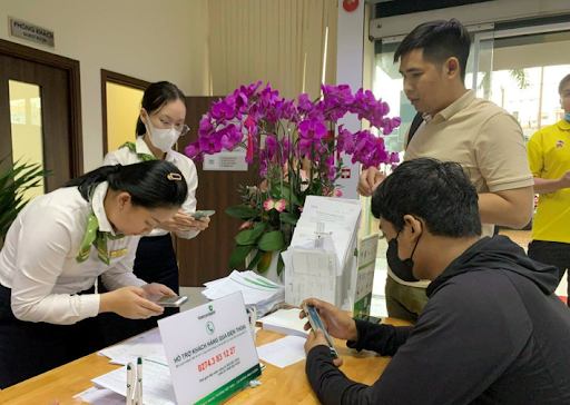 Nhân viên Vietcombank tích cực hướng dẫn khách hàng cập nhật sinh trắc học tại quầy giao dịch Nhân viên Vietcombank tích cực hướng dẫn khách hàng cập nhật sinh trắc học tại quầy giao dịch