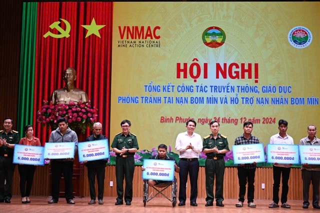 Representatives of the Việt Nam National Mine Action Centre give presents to mine victims in Bình Phước Province. — Photo courtesy of the VNMAC Representatives of the Việt Nam National Mine Action Centre give presents to mine victims in Bình Phước Province. — Photo courtesy of the VNMAC