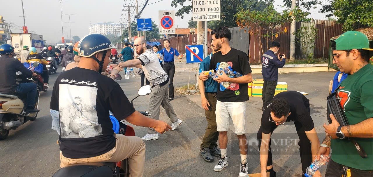 Foreigners enthusiastically gave away tens of thousands of bottles of mineral water to people returning home to celebrate Tet At Ty, District 12. (Photo: Chinh Hoang/Dan Viet Newspaper) Foreigners enthusiastically gave away tens of thousands of bottles of mineral water to people returning home to celebrate Tet At Ty, District 12. (Photo: Chinh Hoang/Dan Viet Newspaper)
