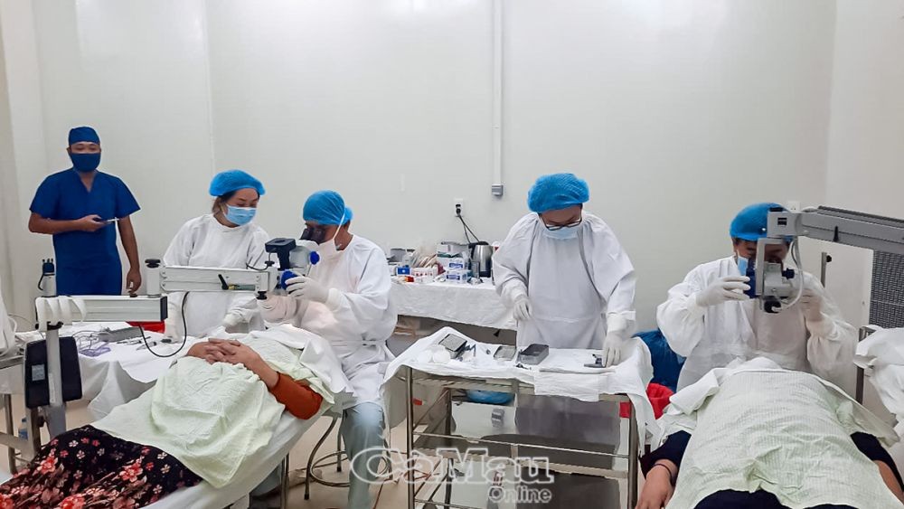 Các bác sĩ Trung tâm Y tế huyện Ngọc Hiển (Cà Mau) kết hợp với các bác sĩ tuyến trên để mổ đục thuỷ tinh thể cho bệnh nhân. (Ảnh: Báo Cà Mau) Các bác sĩ Trung tâm Y tế huyện Ngọc Hiển (Cà Mau) kết hợp với các bác sĩ tuyến trên để mổ đục thuỷ tinh thể cho bệnh nhân. (Ảnh: Báo Cà Mau)