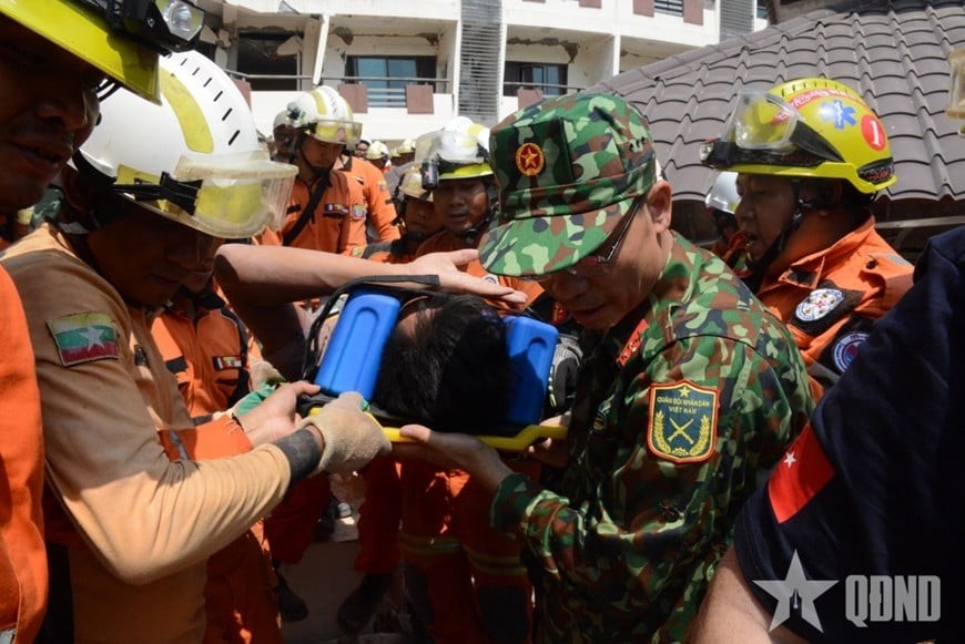 Rescue teams from Vietnam, Myanmar, and Turkey bring victim Htet Maung Maung to the ambulance. (Photo: People's Army Newspaper) Rescue teams from Vietnam, Myanmar, and Turkey bring victim Htet Maung Maung to the ambulance. (Photo: People's Army Newspaper)