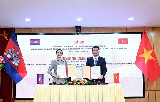 Minister of Industry and Trade Nguyen Hong Dien (R) and Cambodian Minister of Commerce Cham Nimul sign an agreement on promoting Viet Nam–Cambodia trade for the 2025–2026 period, Ha Noi, April 28, 2025. Photo: VGP