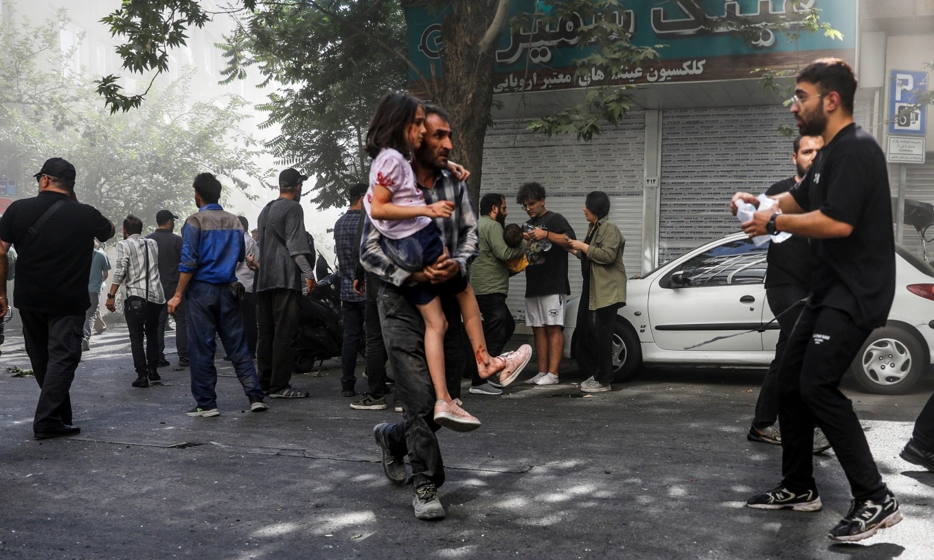 Người đàn ông bế bé gái bị thương sau cuộc không kích của Israel vào Tehran hôm 15/6. (Ảnh: AP) Người đàn ông bế bé gái bị thương sau cuộc không kích của Israel vào Tehran hôm 15/6. (Ảnh: AP)
