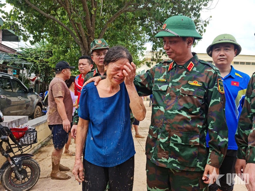  Sau nhiều ngày bị cô lập, người dân vùng lũ xúc động khi lực lượng Quân đội tiếp tế, cứu trợ bằng máy bay trực thăng. (Ảnh: Báo Quân đội nhân dân)