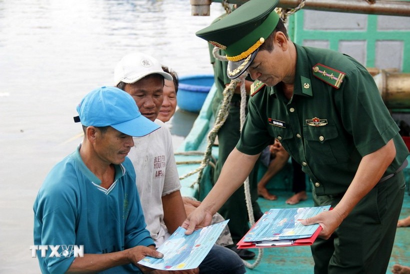 Border guard officers provide fishermen with guidance materials on preventing IUU fishing (Photo: VNA) Border guard officers provide fishermen with guidance materials on preventing IUU fishing (Photo: VNA)