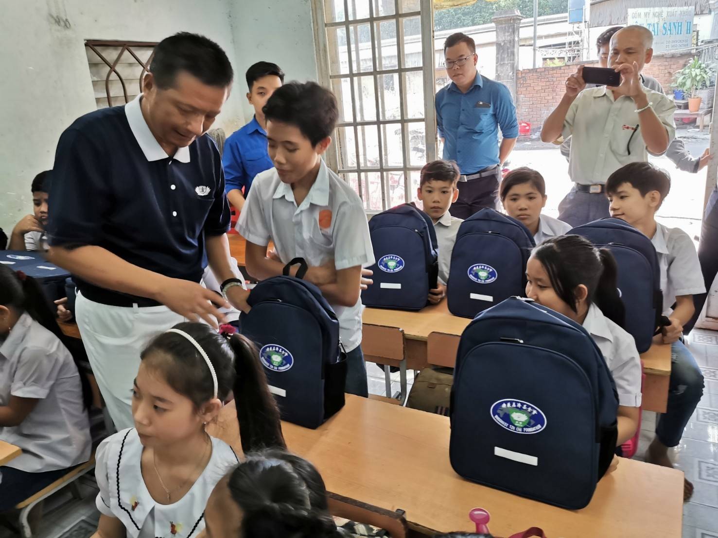 Ông Chen Ta Yu (bìa trái) tặng balo và dụng cụ học tập cho lớp học tình thương ở Bình Dương (nay là thành phố Hồ Chí Minh) ngày 26/11/2019. (Ảnh: Tzu Chi) Ông Chen Ta Yu (bìa trái) tặng balo và dụng cụ học tập cho lớp học tình thương ở Bình Dương (nay là thành phố Hồ Chí Minh) ngày 26/11/2019. (Ảnh: Tzu Chi)
