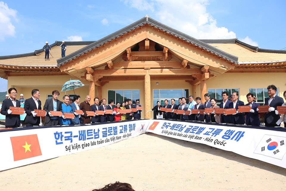 Vietnamese and Korean delegates sign roof tiles for the topping-out ceremony of the Community House in Bonghwa. (Photo: Khanh Van/VNA)