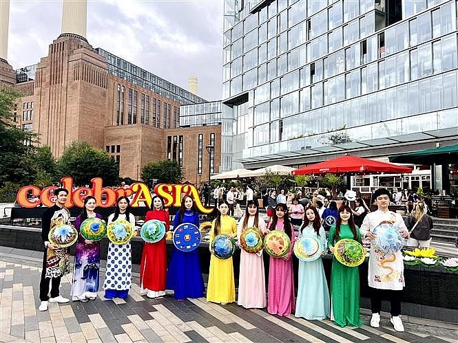 The Vietnamese delegation parades in traditional ao dai and conical hats along the streets of London. (Photo published by VNA)