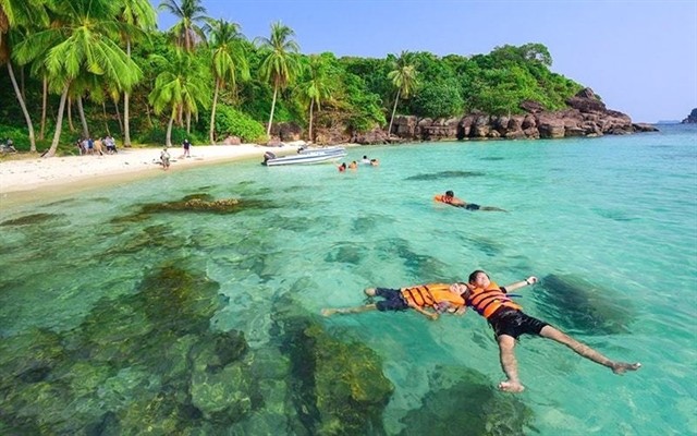 Tourists enjoy the clear water at the Hòn Mây Islet in Phú Quốc. Photo kiengiangtravel.vn Tourists enjoy the clear water at the Hòn Mây Islet in Phú Quốc. Photo kiengiangtravel.vn