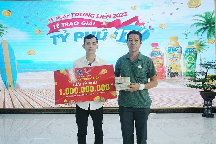 Nguyễn Hoàng Em and his father received a 1-billion-VND prize from Number 1’s “Tear and Win” program in 2023. Photo: Tân Hiệp Phát.